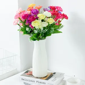 Artificial rose flower bouquet in white ribbed vase, home living room decorative tabletop display.