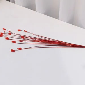 Red artificial decorative flower branch detail, slender stem for home wedding floral arrangement.
