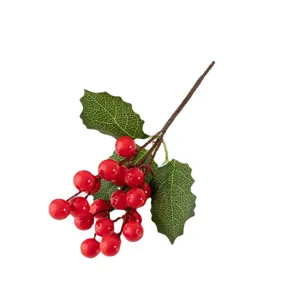 Bacche rosse artificiali e foglie di agrifoglio per decorazioni natalizie e Capodanno.