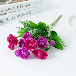 Detailed close-up view of artificial purple and pink rose flower bouquet with green leaves.