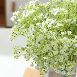 Gros plan de fleurs artificielles de gypsophile aux délicates petites têtes blanches et tiges.
