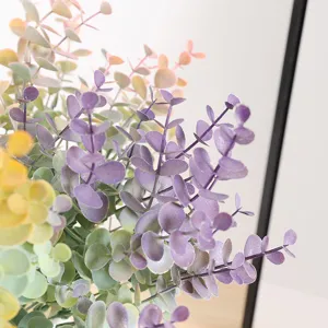Artificial eucalyptus leaves detail shot, vibrant purple, green and yellow gradient decor.