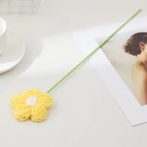 Handmade knitted yellow flower detail shot, perfect for cozy home decor and tabletop staging.
