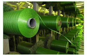 Industrial grade artificial grass turf yarn rolls factory stock display, green PE yarn material.