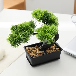 Artificial bonsai tree detail, small fake green plant in black pot for home decor.