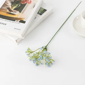 Blue artificial baby breath flower stem close up, plastic flora decor detail for home.