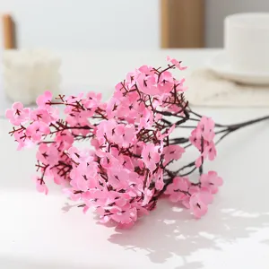 Close-up detail of pink artificial flower branch, elegant floral arrangement for home decor.