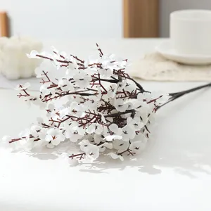 Detailed shot of artificial white plum blossom branch fake silk flower for home decor