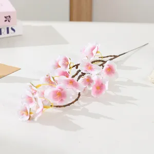 Artificial pink cherry blossom branch detail, realistic floral decor for home and wedding.