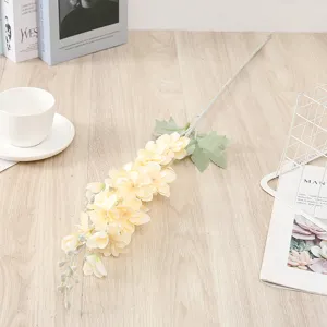 Detailed view of artificial yellow delphinium silk flower branch for home decor and wedding.
