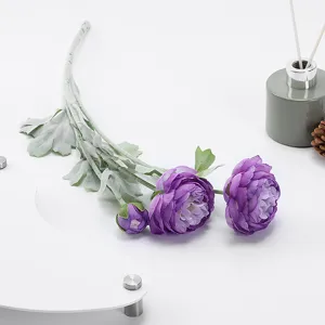 Close-up detail shot of artificial purple ranunculus flower with flocked green stem setup.