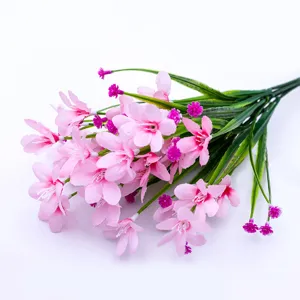 Detail shot of pink artificial flower bouquet with green stems and delicate petals.
