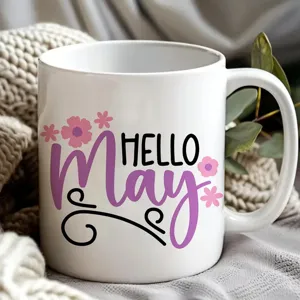 Vista di dettaglio di una tazza in ceramica bianca con stampa floreale hello may.
