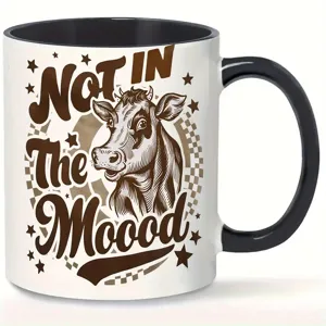Keramik Kaffeetasse mit witzigem Kuh-Motiv und Spruch, schwarzer Henkel, ideal für Büro und Alltag.