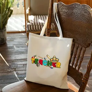 Vista detallada del bolso de lona blanca con estampado gráfico colorido de temática de profesor.