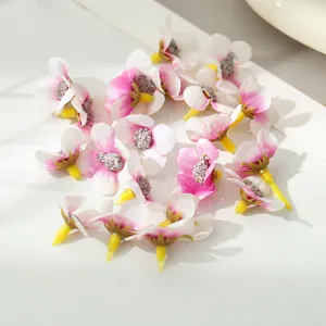 Nahaufnahme von künstlichen Mini-Seidenblumenköpfen in Rosa und Weiß für DIY-Bastelprojekte.