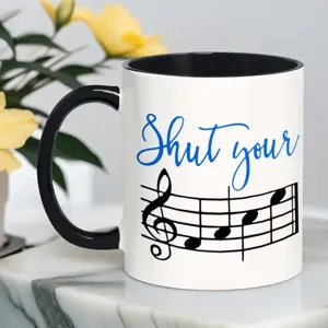 Primo piano dettagliato di una tazza da caffè in ceramica bianca con manico nero e design stampato.