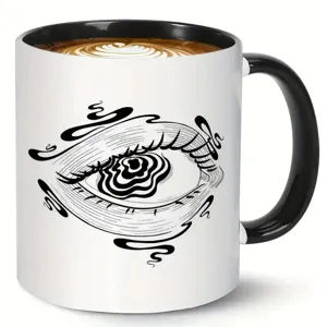 Ceramic coffee mug with abstract eye art design, black and white office cup for daily use.