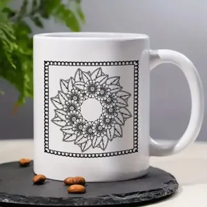White ceramic coffee mug featuring black floral mandala pattern, ideal for office and home.