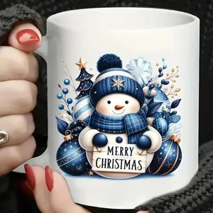 Detailansicht einer weißen Keramiktasse mit süßem blauem Weihnachtsschneemann-Motiv.