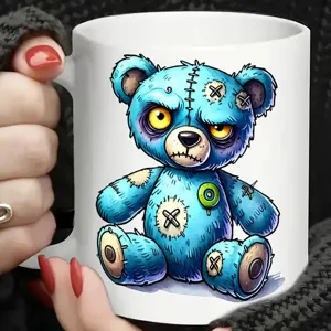Detailaufnahme der weißen Keramik Kaffeetasse mit einzigartigem blauen Plüschbär Motiv Print.
