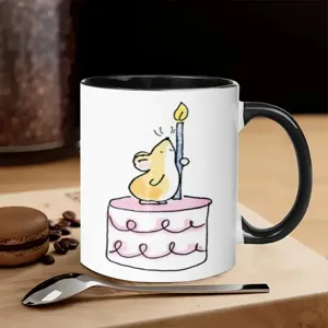 Detailed ceramic coffee mug with cute hand-drawn mouse illustration and cozy tabletop scene view.