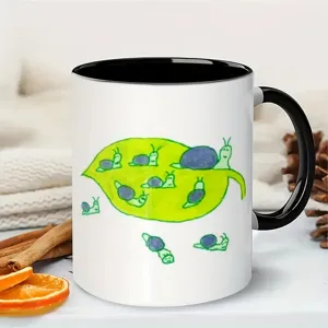 Close-up detail of a ceramic coffee mug featuring a cute cartoon snail leaf art design on desk.