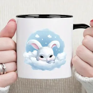 Encantadora taza de café de cerámica con lindo conejo blanco en nubes para oficina y hogar.