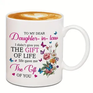 Vue rapprochée de tasse à café en céramique blanche avec texte floral et papillon personnalisé.