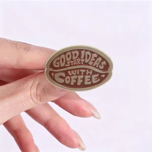 Gedetailleerde close-up van een vintage koffieboon geëmailleerde broche met tekst. Metaal.