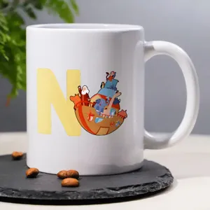 Close-up shot of white ceramic coffee mug featuring custom letter N and cute animal boat graphic.