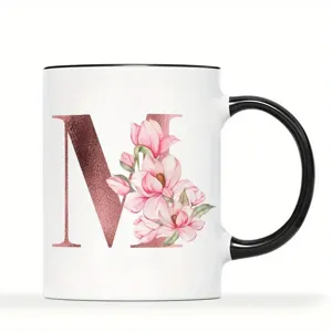Nahaufnahme Detail der weißen Keramik Tasse mit schwarzem Henkel und Roségold Buchstabe.