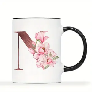 Detailansicht der Keramiktasse mit schwarzem Rand, Henkel und floralem N-Buchstaben.