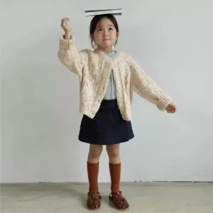 Vista dettagliata del cardigan in maglia a pois colorati per bambini, morbido abbigliamento.