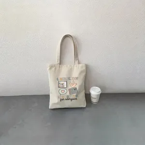 Vista dettagliata della borsa in tela, stile moda casual con design stampato e manici.