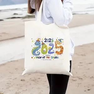 Vista dettagliata del design della borsa in tela con tema serpente 2025 presentata sulla spiaggia.