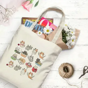 Vista dettagliata di una borsa shopper in tela con stampa di gatti carini, fiori e accessori.