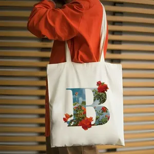 Primo piano dettagliato di elegante borsa tote in tela bianca con motivo floreale.