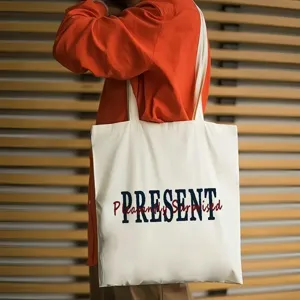 Borsa shopper in tela bianca dettaglio, con stampa di lettere blu e rosse, stile casual.