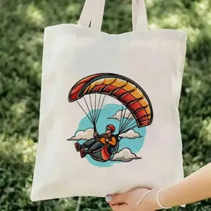Λευκη τσαντα καμβα με ζωντανρη εικονογραφηση αλεξιπτωτου πλαγιας, ιδανικη για εξωτερικους χωρους.