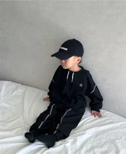 Kids black tracksuit set long sleeve sweatshirt and pants with contrast stitching detail.