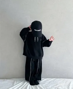 Kids black hooded tracksuit set with contrast stitching and matching cap for spring casual wear.