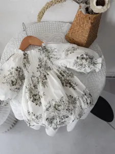 Detailed view of infant vintage floral baby romper with smocked long lantern sleeves.