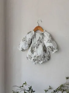 Detailed view of baby girl vintage floral smocked romper with long balloon sleeves.