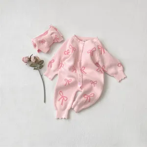 Pink knitted baby romper with cute bow pattern, comfortable long sleeve detail view.