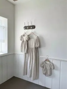 Detailed shot of baby girl cotton floral embroidered puff sleeve romper and matching dresses.