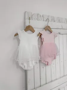Détail de grenouillère bébé été en tulle manches volantes, joli style robe combinaison.