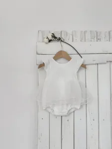 Vue détaillée d'un joli body blanc pour bébé fille avec jupe en tulle et volants doux.