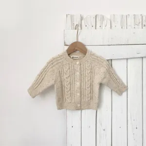 Primo piano del bellissimo cardigan in maglia per neonato con puntini colorati e bottoni.