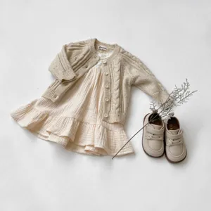 Set cardigan in maglia e abito per neonati, grazioso dettaglio di vestito invernale.